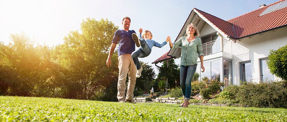 Una familia feliz con una casa de fondo